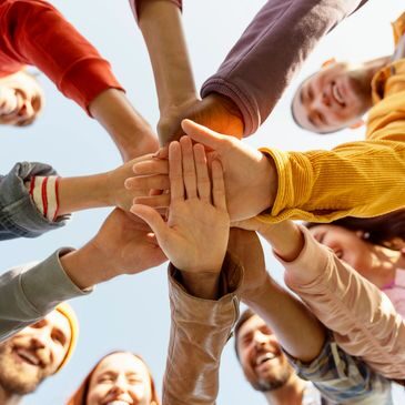 Smiling team stacking hands in unity