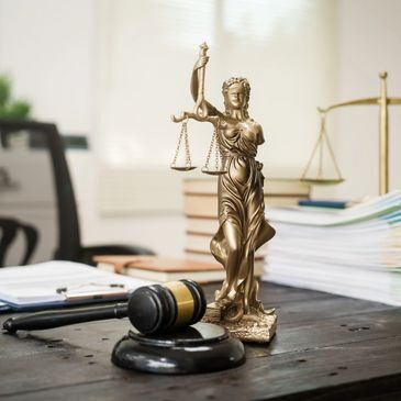 Lady Justice statue with gavel and law books